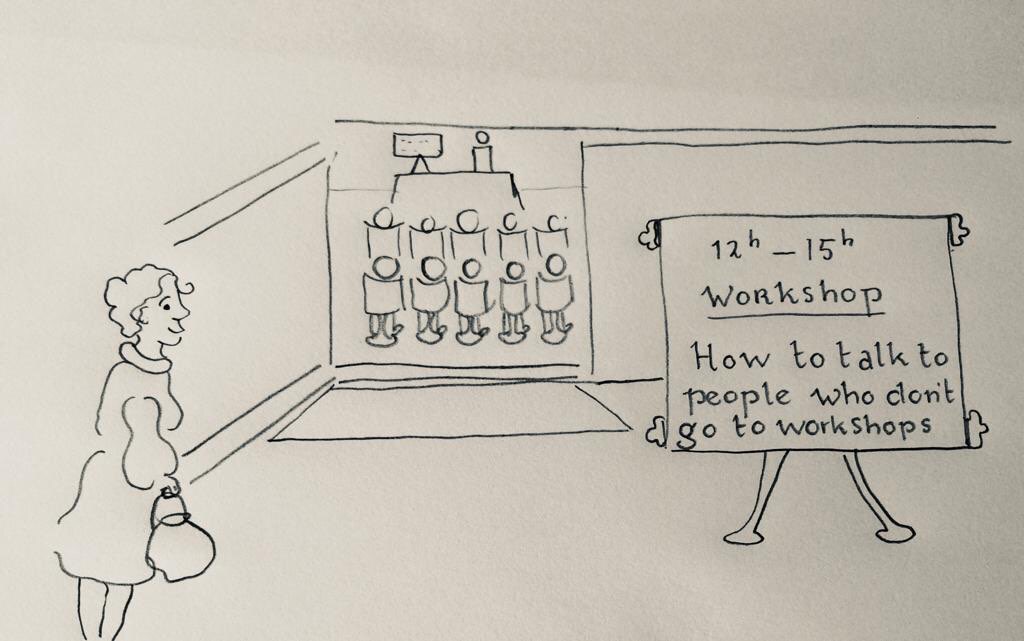 A cartoon with a woman-like person who looks at a sign which says: Workshop - how to talk to people who don't go to workshops.